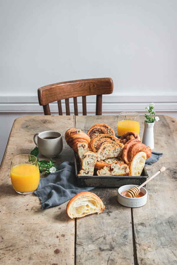 Scène de petit déjeuner avec des viennoiseries et des verres de jus d'orange sur une jolie table en bois ancienne