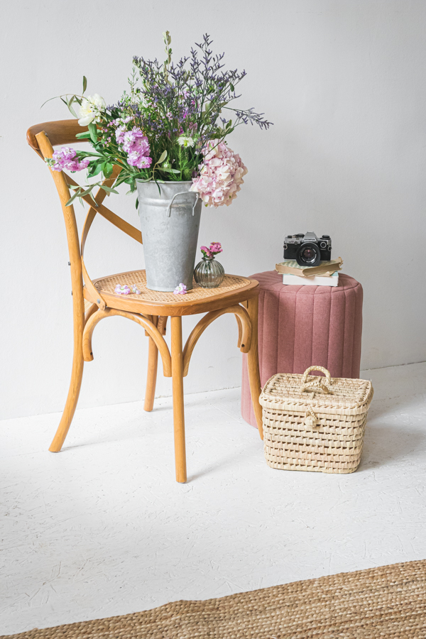Une scène autour d'une chaise en bois, de fleurs et d'accessoires