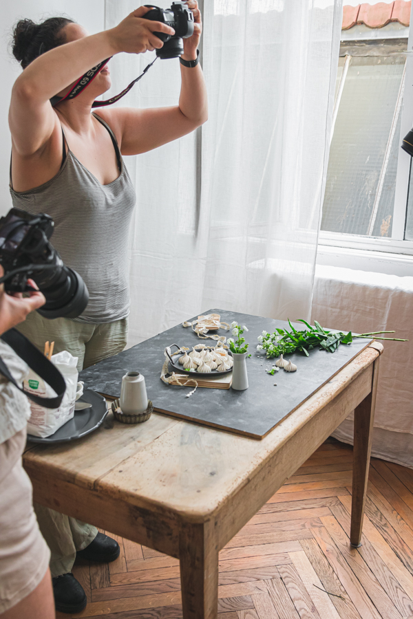 Scénographie autour de jolie petites meringues, une participante de l'atelier est en train de photographier la scène de dessus