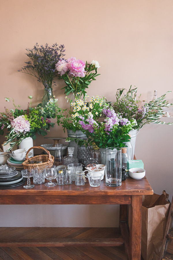 Une table en bois supporte des accessoires et des fleurs lors d'un workshop de photographie culinaire
